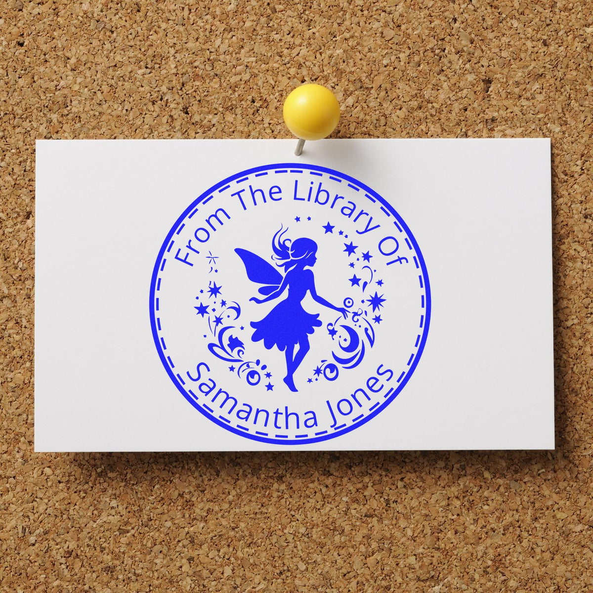 Blue library stamp seal on white card, pinned to corkboard with yellow pushpin, featuring fairy silhouette and Samantha Jones.