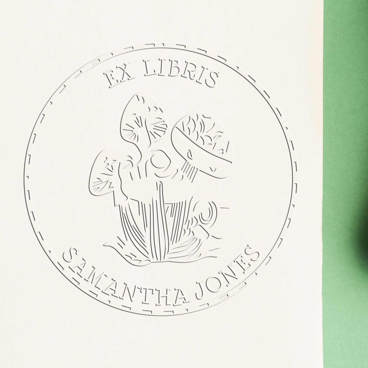 Embossed circular ex libris bookplate seal with floral design on white paper, bordered by green.