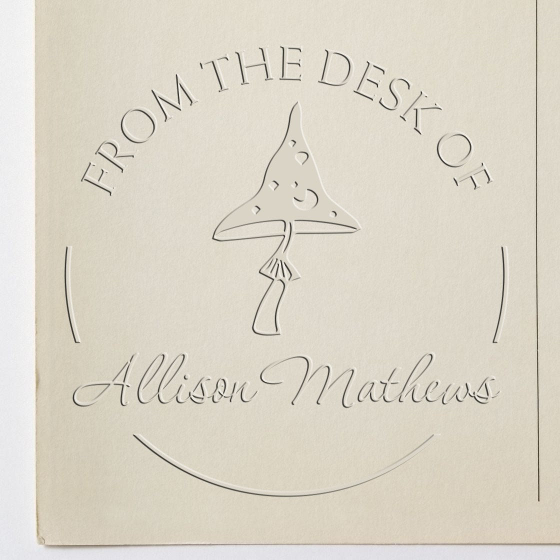 Cream embossed stamp seal for Allison Mathews, with From the Desk of text and a stylized pen nib logo.