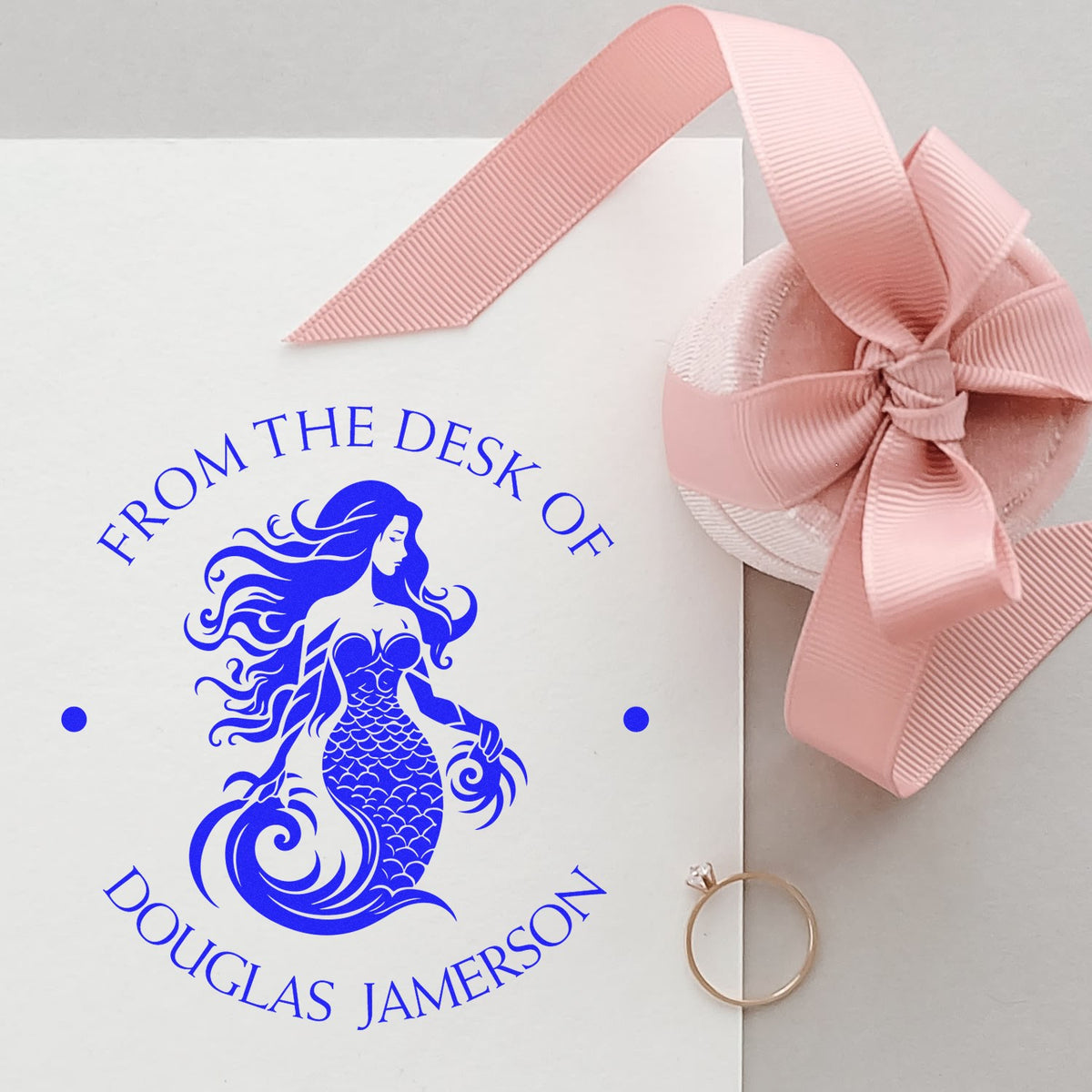 Blue mermaid custom stamp on white card, accented by a pink ribbon wax seal and gold ring.
