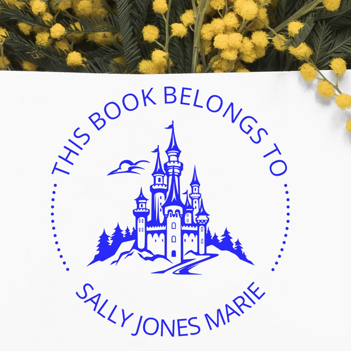 Blue custom book stamp seal with castle logo and This Book Belongs to Sally Jones Marie on white, with yellow flowers.
