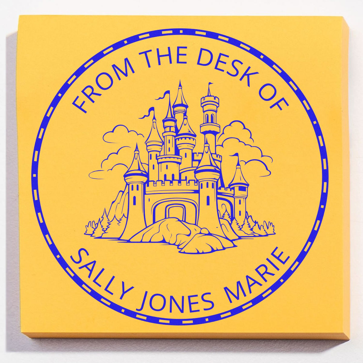 Yellow custom desk seal stamp with blue castle emblem and circular text reading ÂFrom the Desk of Sally Jones MarieÂ
