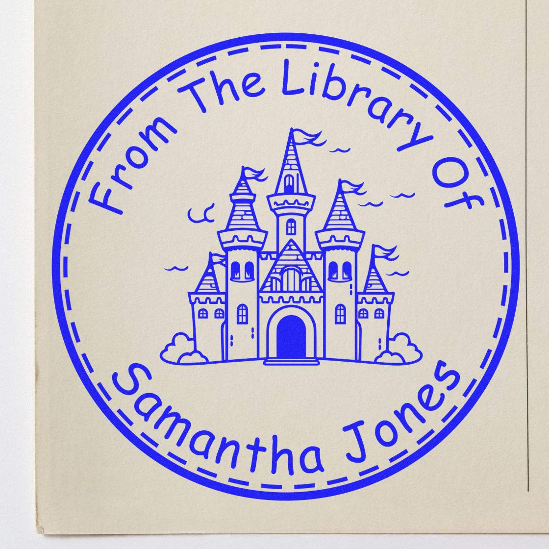 Blue circular stamp seal with castle and text From The Library Of Samantha Jones on cream paper.