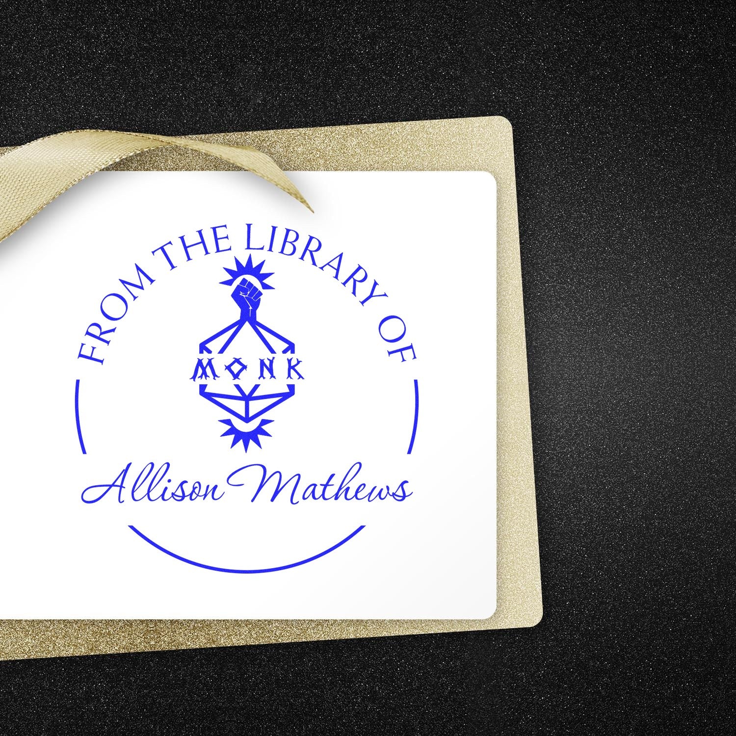 Blue library stamp seal for Allison Mathews on a white card with a gold glitter border and ribbon.