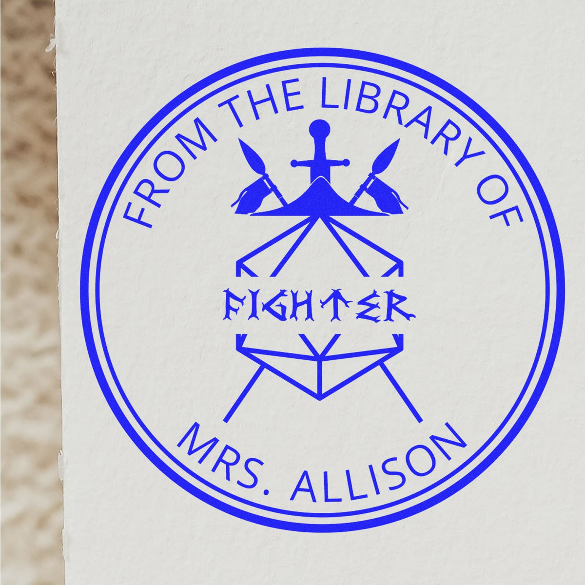 Blue circular library stamp seal reading From the Library of Fighter Mrs. Allison with anchor-and-pencils emblem.