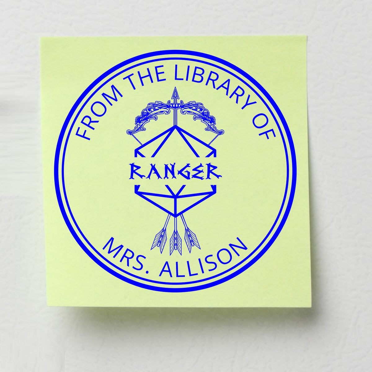 Blue custom library seal stamp with circular border and From the Library of Ranger Mrs. Allison on pale yellow paper.