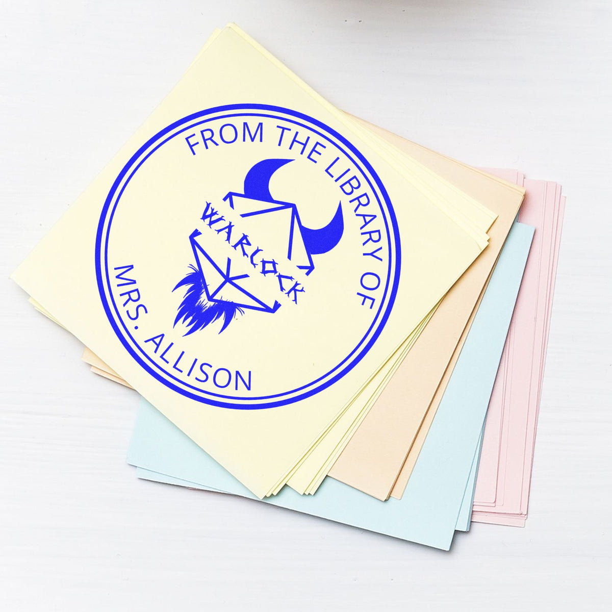 Stack of pastel stamp and seal sheets with a blue circular library stamp reading From the Library of Mrs. Allison.