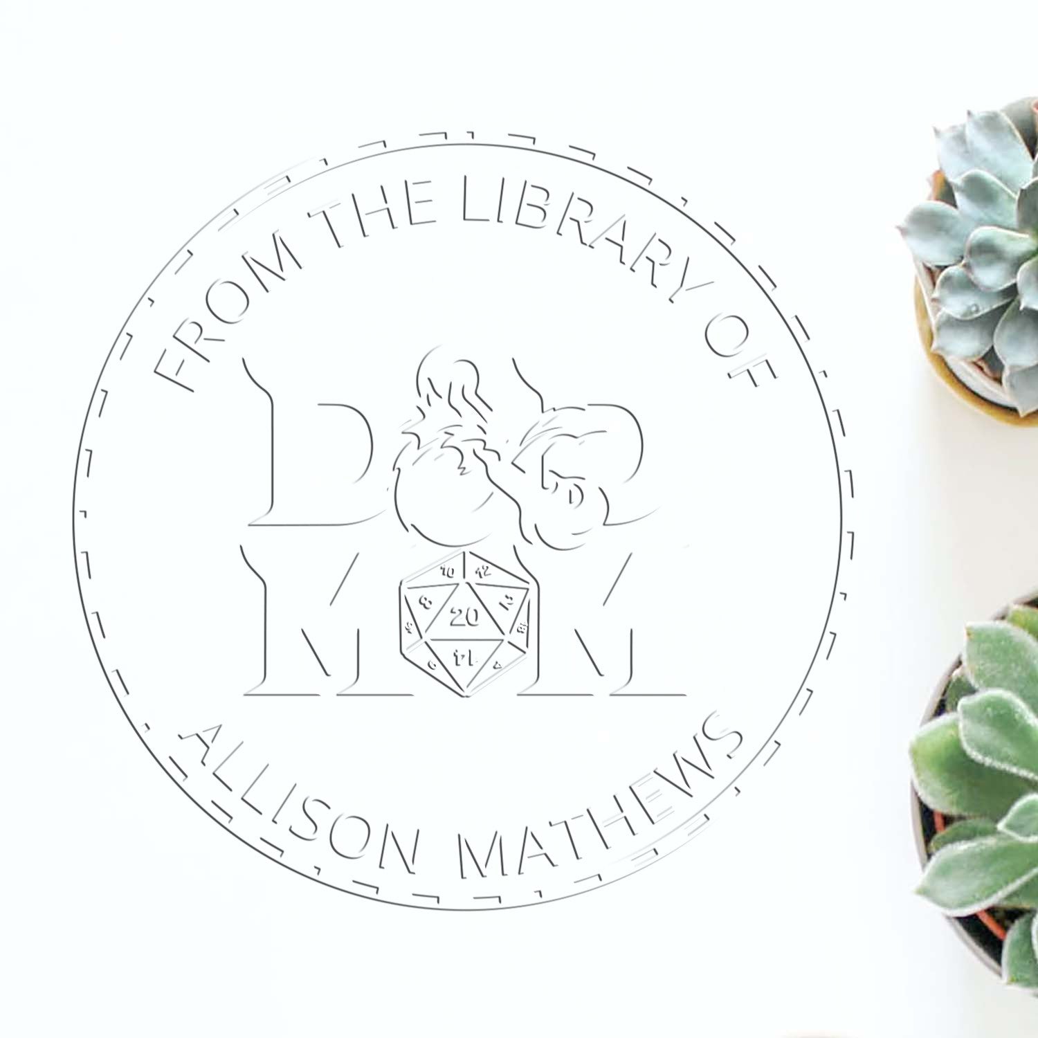 Circular gray library stamp seal with floral monogram and dice, reading “From the Library of Allison Matthews.”