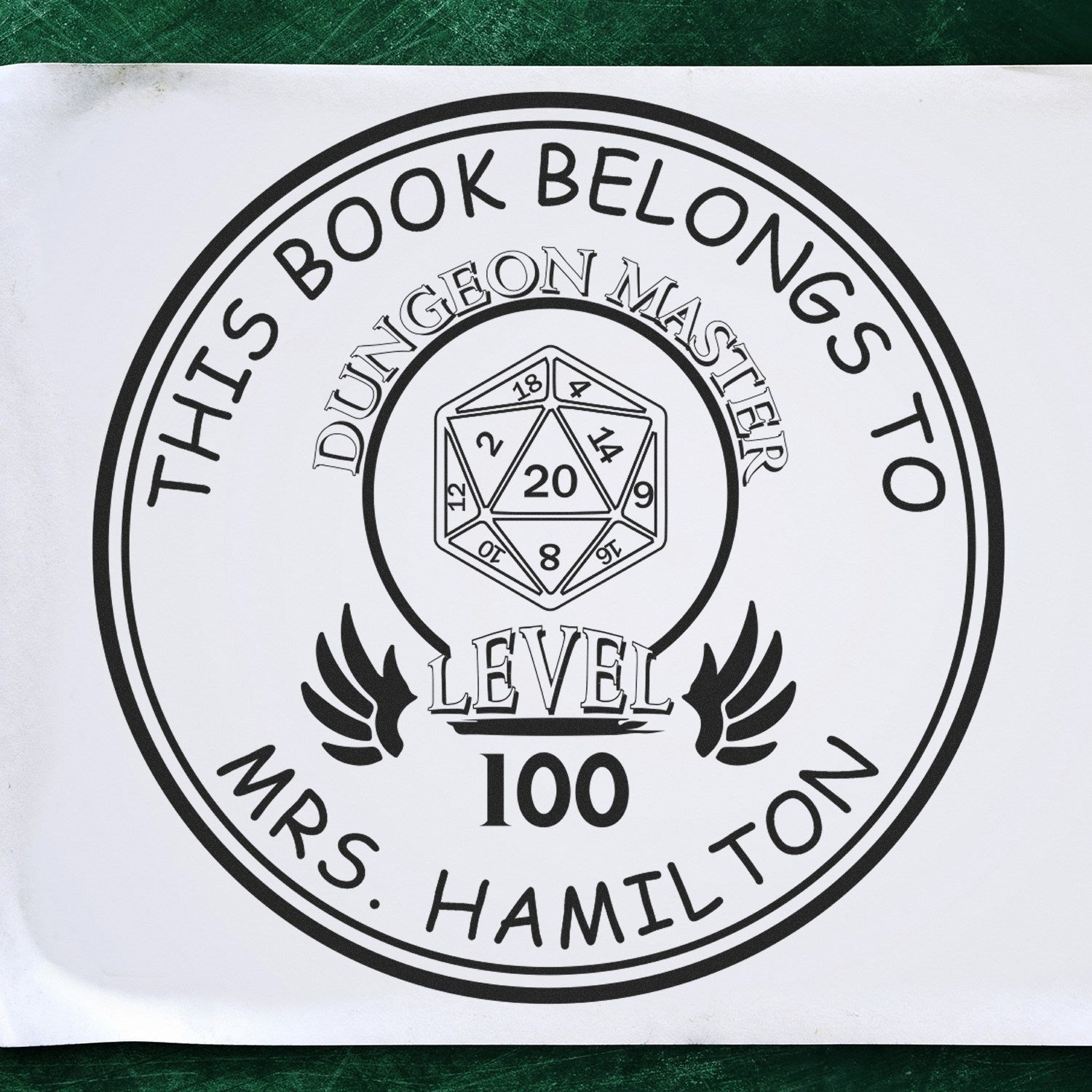 Image of a custom-made new address stamper featuring a circular design with "This Book Belongs To" text. The stamp includes a cartoon animal, a Wood Handle WhiskerTwist, and is a personalized book lover gift. The center shows a "Dungeon Master Level 100" emblem.