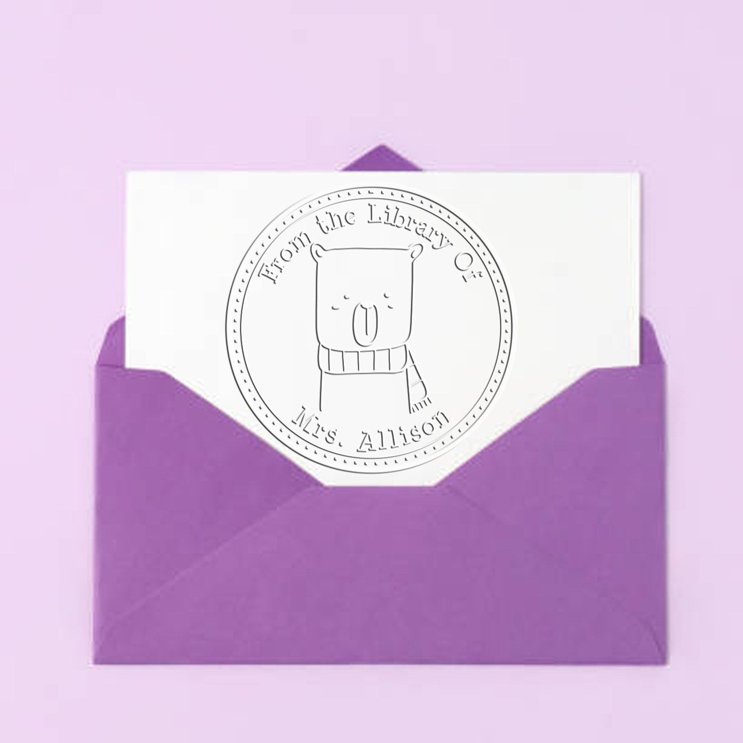 Purple envelope with a white card featuring a Soft BounceTail cartoon animal design. The card is embossed with a custom-made book embosser reading "From the Library Of Mrs. Allison." This serves as a custom mailing stamper.