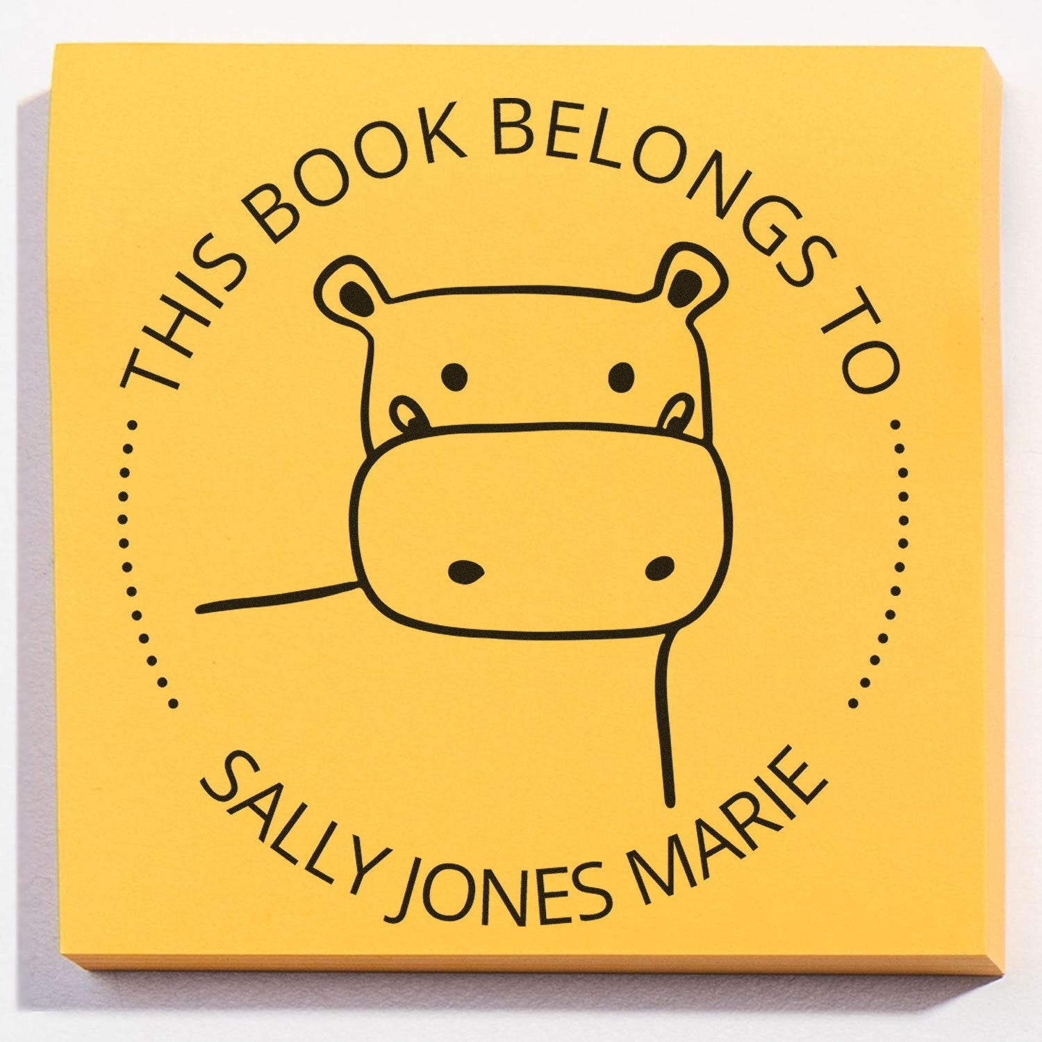 Wood handle TizzyTwitch cartoon animal customized book stamp with a hippo design and text "This Book Belongs To Sally Jones Marie" on a yellow background. Includes a custom new address stamper feature.