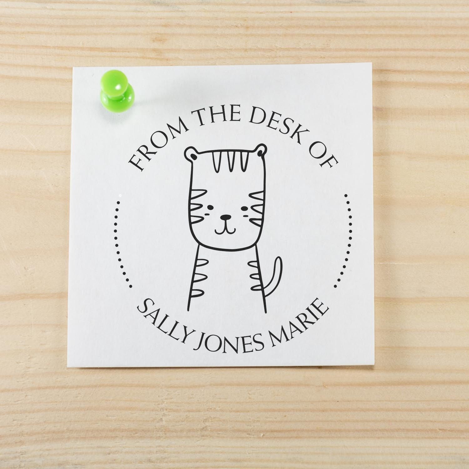 Wood Handle TizzyTumble Cartoon Animal Customized Book Logo Stamp on a wooden surface. The stamp features a cute animal design with customizable text, ideal for a Customizable Address Stamper. A green pushpin secures the stamped paper.