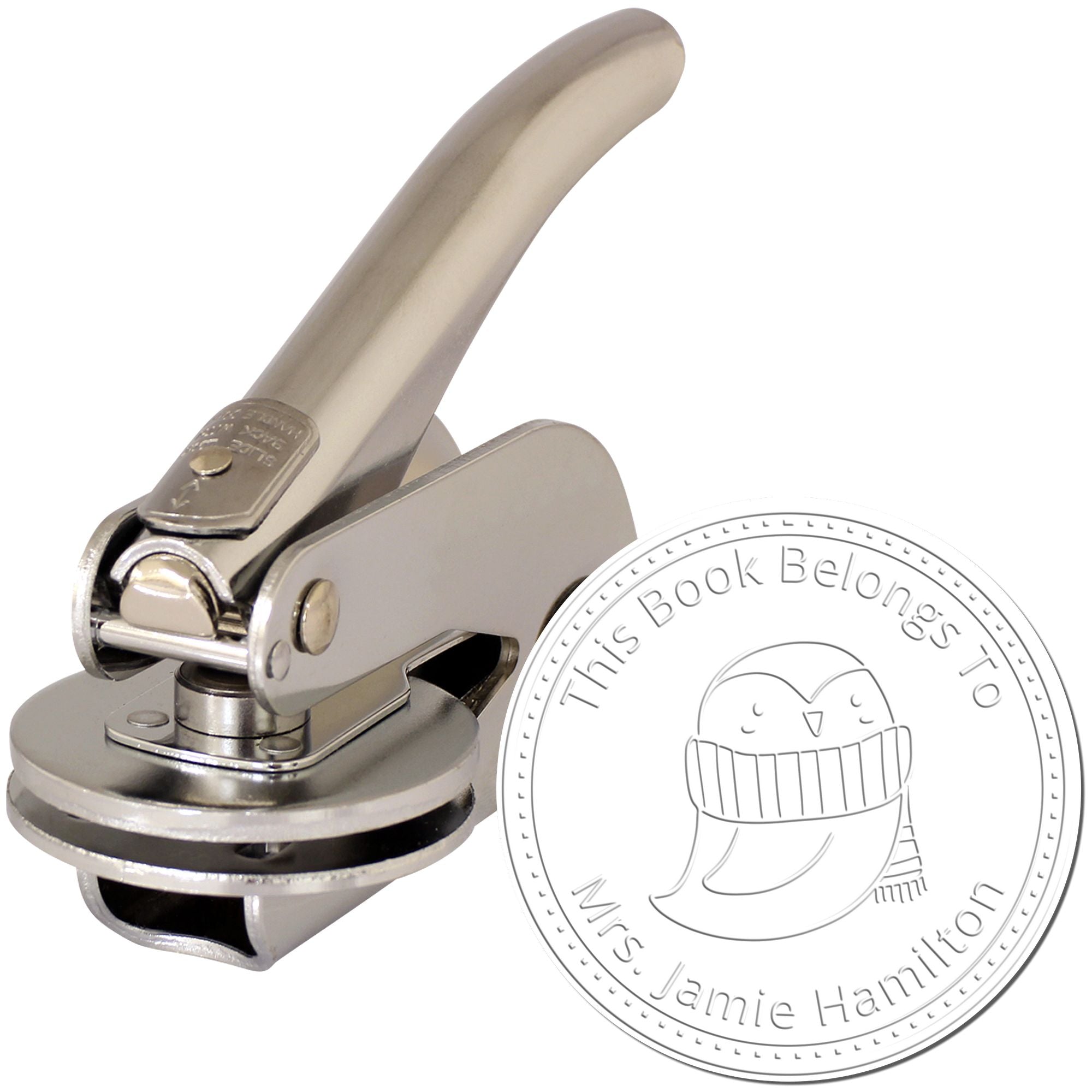 A handheld embosser with a metal handle is shown next to an imprint featuring a QuirkyQuack cartoon animal. The text reads "This Book Belongs To Mrs. Jamie Hamilton." Keywords: Personalized Library Book Belongs To Embosser, Customizable Mailing Stamp.