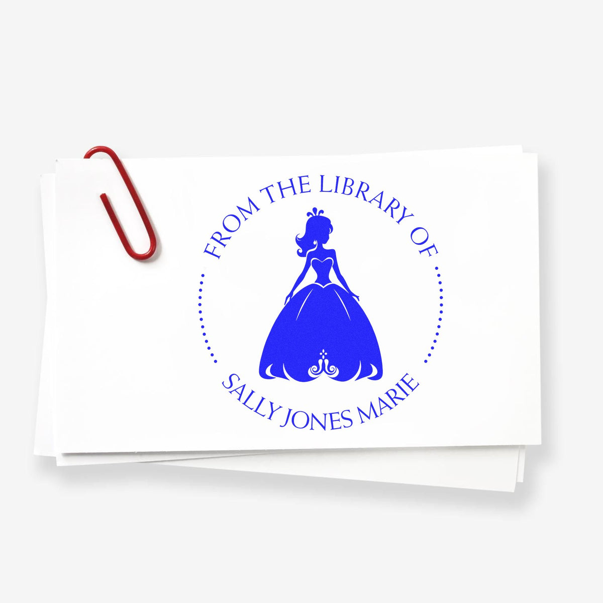 Custom blue library stamp seal with princess silhouette on white paper, clipped with a red paperclip.