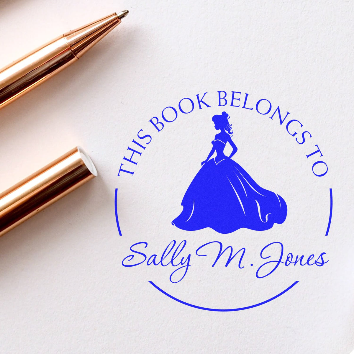 Rose gold stamp and seal set beside a blue princess bookplate reading This Book Belongs to Sally M. Jones.