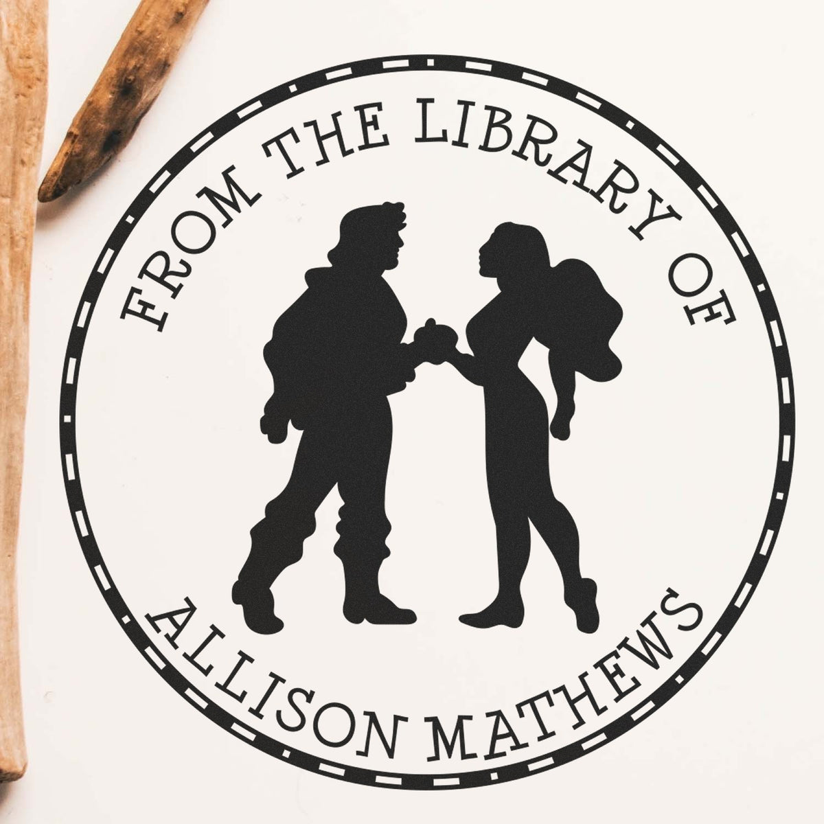 Black circular library stamp seal with two silhouetted figures and From the Library of Allison Mathews text.