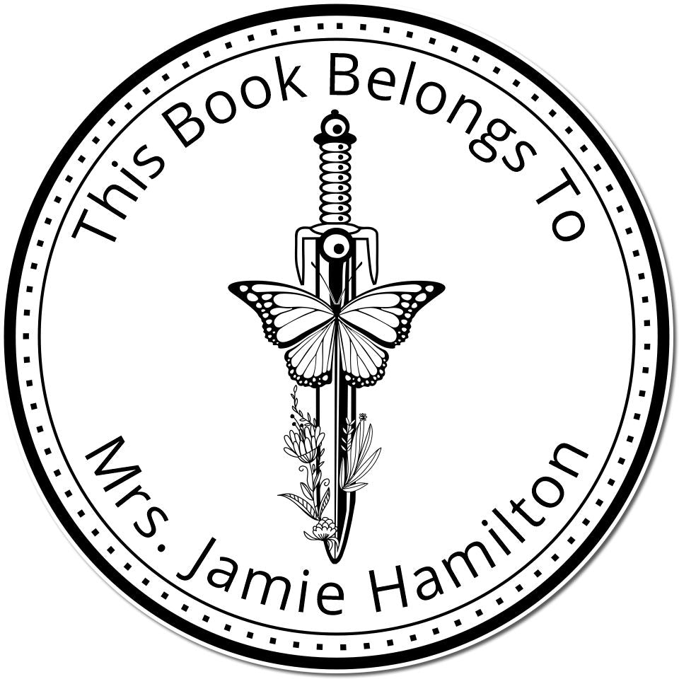 Black circular bookplate stamp seal with butterfly over sword and floral details, reading ÂThis Book Belongs To Mrs. Jamie HamiltonÂ.