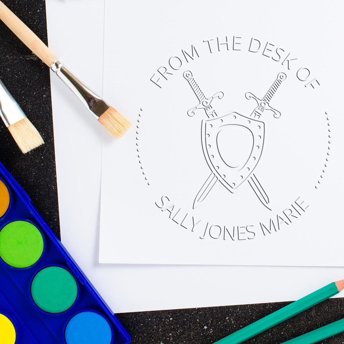 White embossed stamp seal with crossed swords and shield on paper, beside colorful paint brushes, palette, and pencils.