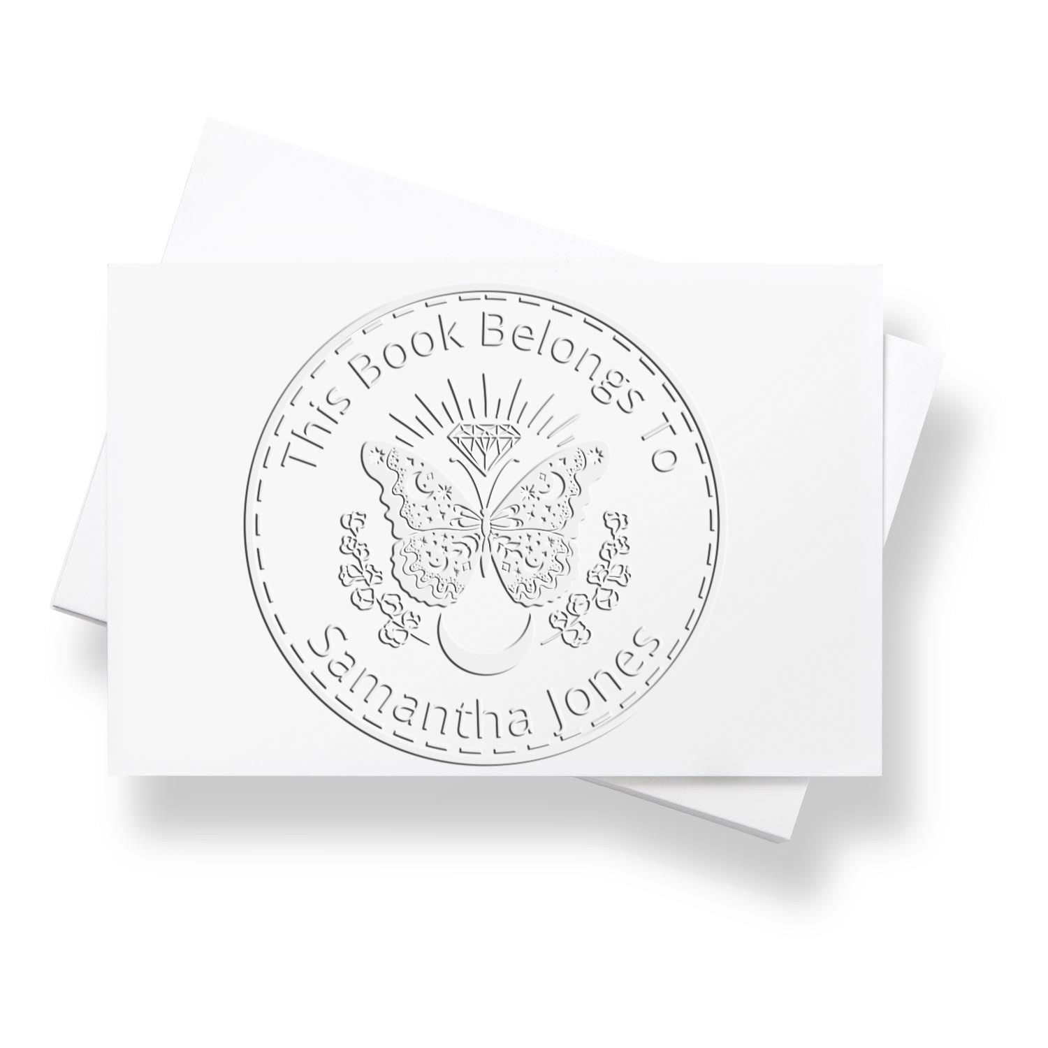 White custom bookplate seal stamp with butterfly, diamond and floral details, embossed for Samantha Jones on white cards.