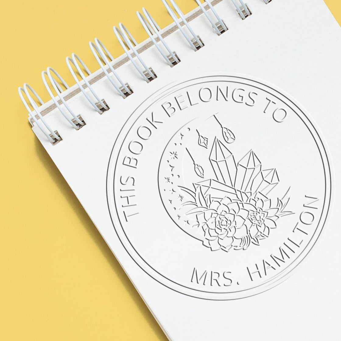 ESS Seraphine's Gaze Mystic Handheld Astrological Stamp in use, featuring custom embossed design on paper.