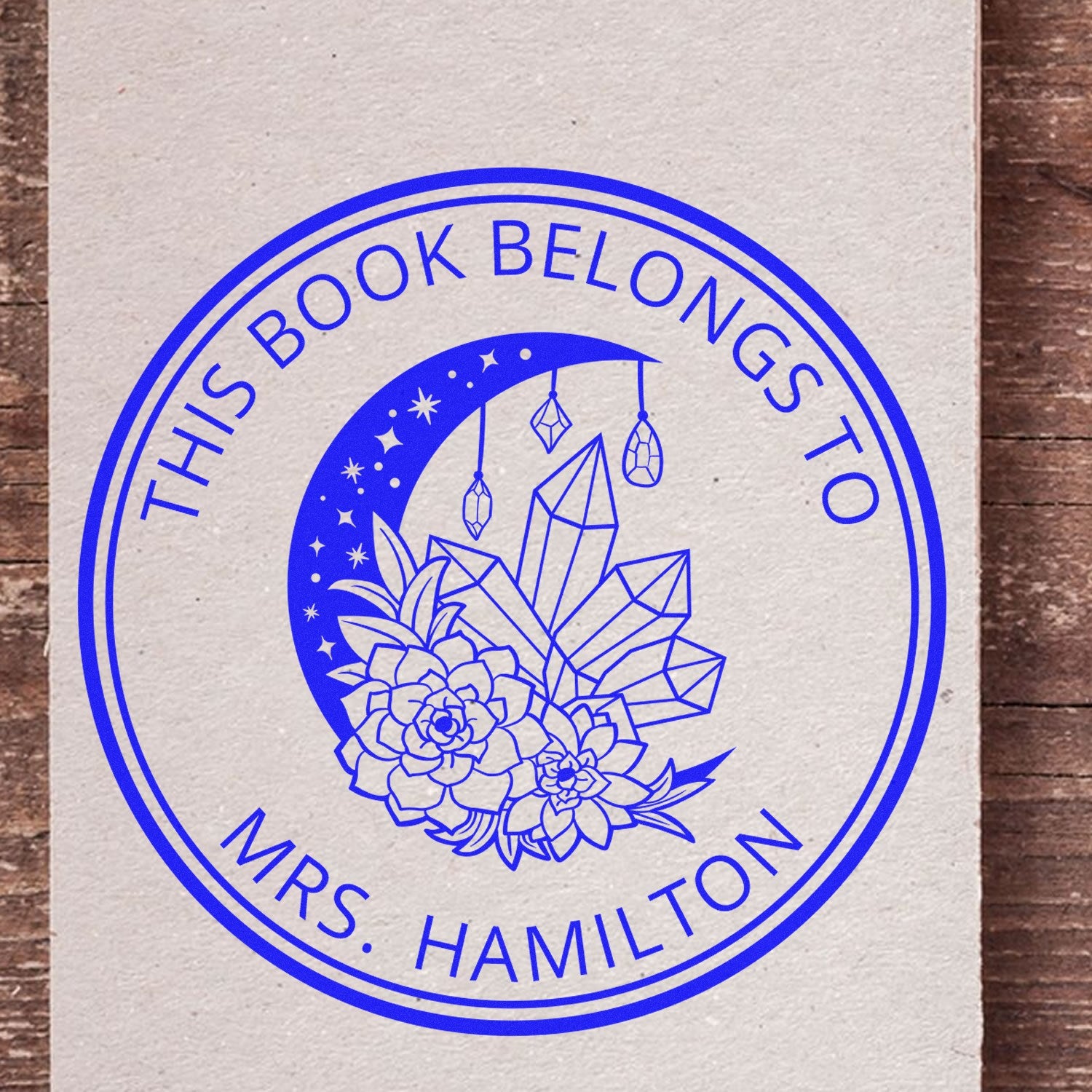 Blue personalized book stamp seal with crescent moon, crystals, and flowers for Mrs. Hamilton.
