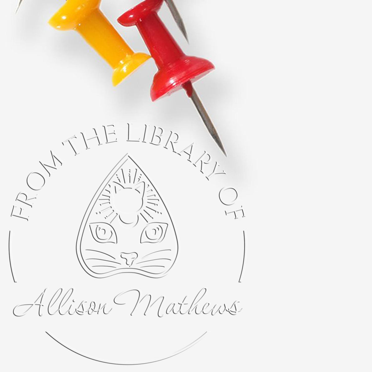 Yellow and red push pins beside an embossed library seal with cat emblem and Allison Matthews text.