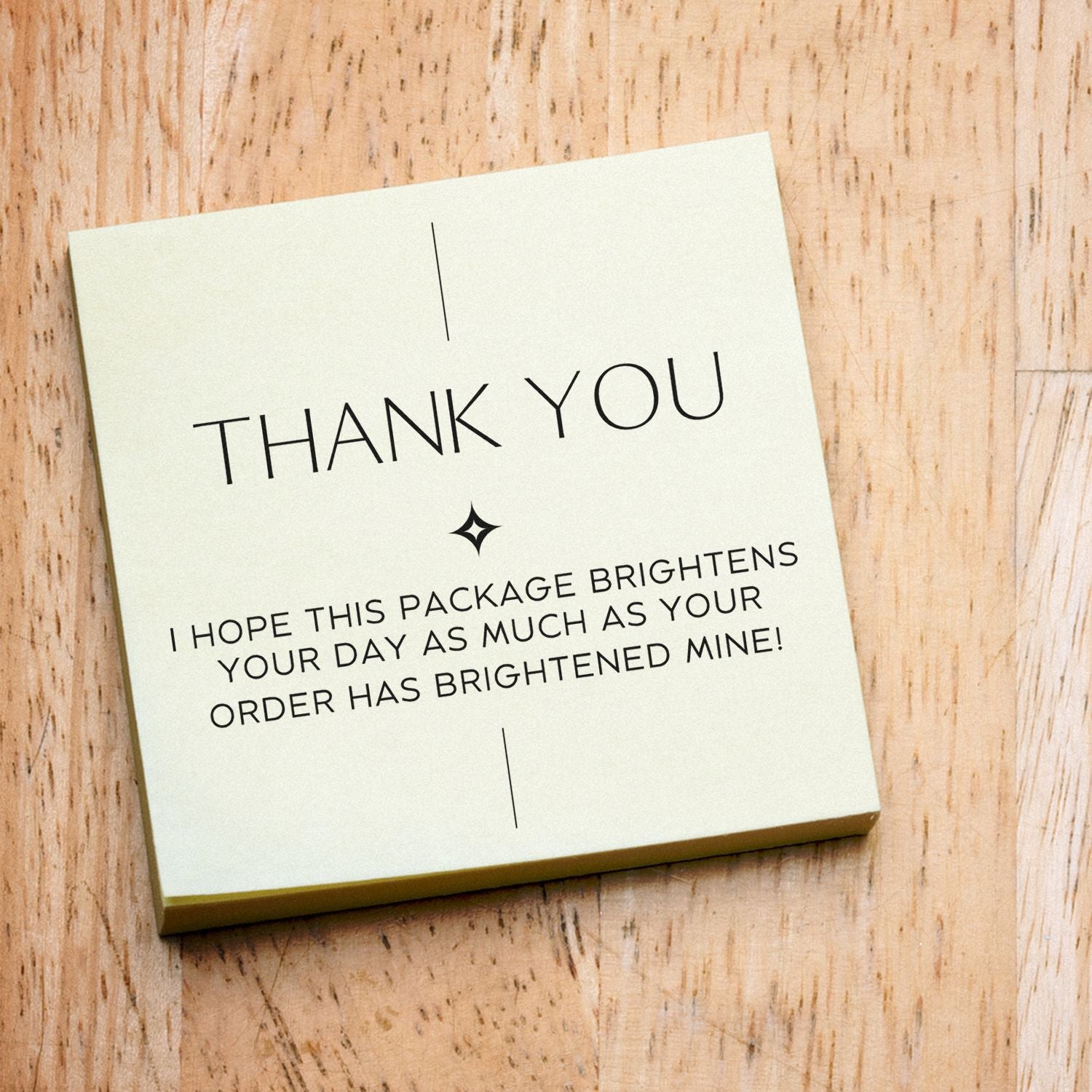 Cream thank-you stamp and seal card with black text and star icon on a light wood background