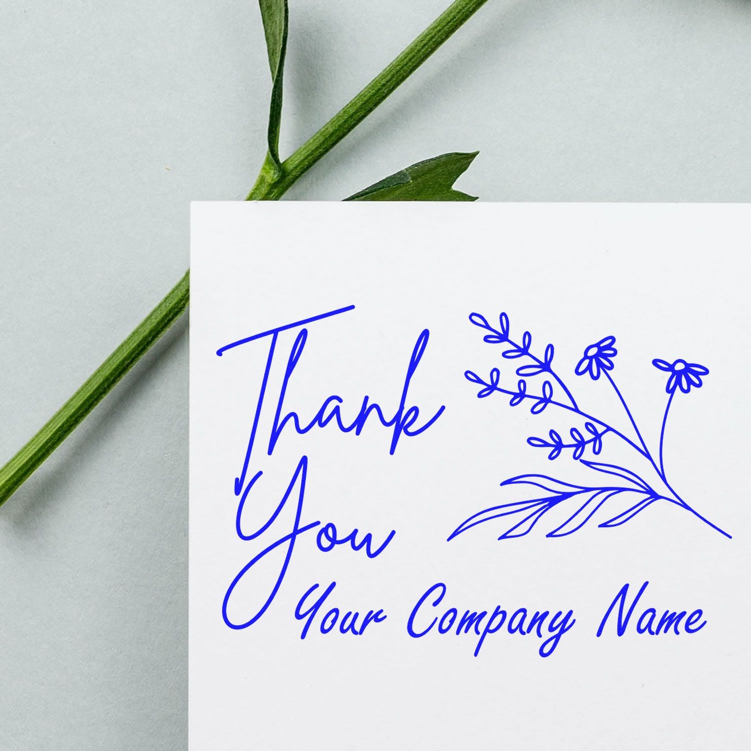 Blue thank you stamp and seal with floral branch and custom company name on a white card with green stems.