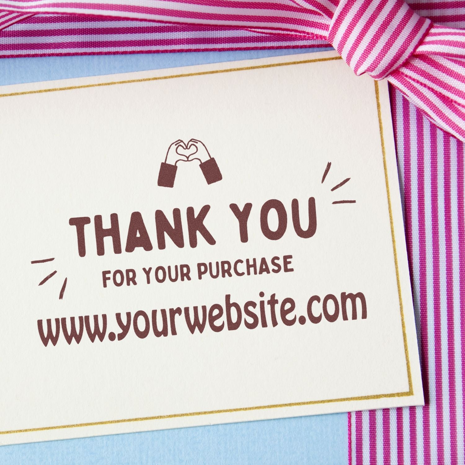 Burgundy thank-you stamp on white card with gold border, pink striped ribbon, and hands-heart icon for purchase seal.