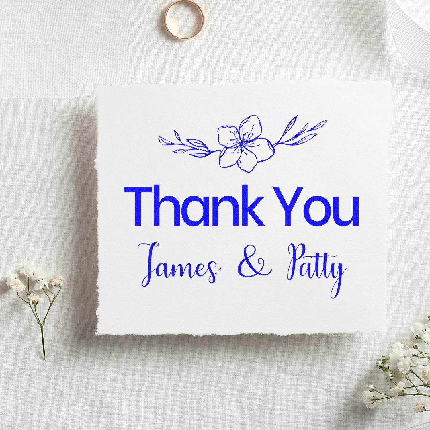 Custom blue floral thank you stamp seal reading James & Patty on white textured paper.