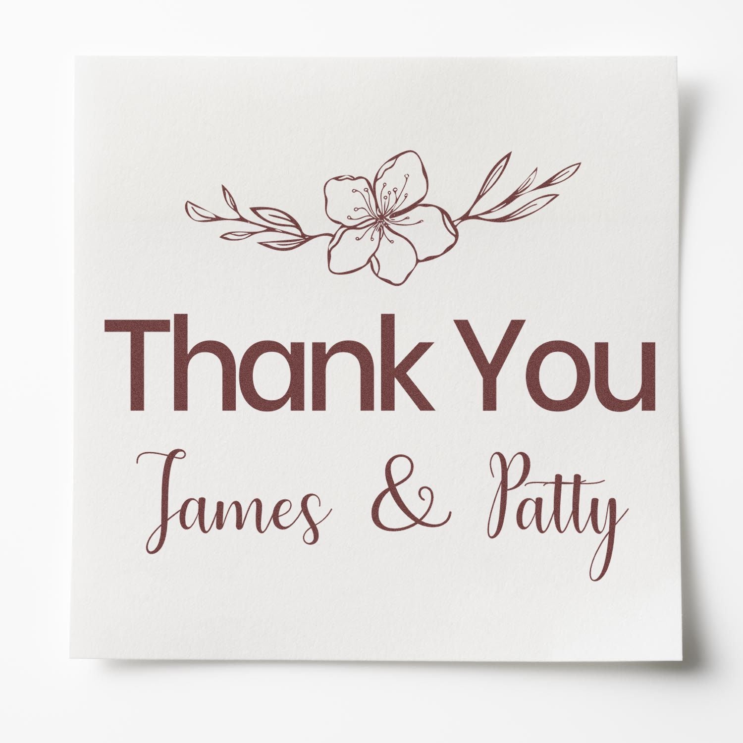 Maroon floral custom stamp and seal reading Thank You James & Patty on white paper.