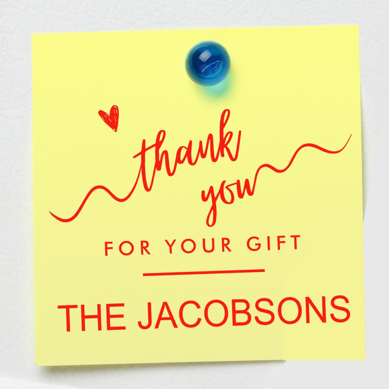 Yellow thank-you gift seal stamp with red lettering and heart, pinned by a blue tack: The Jacobsons.