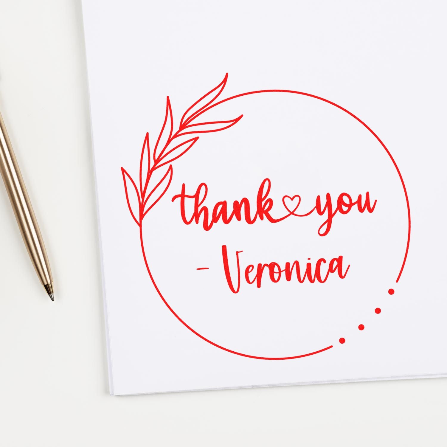 Red circular thank-you stamp seal with leaf wreath and Veronica on white paper, beside a gold pen.