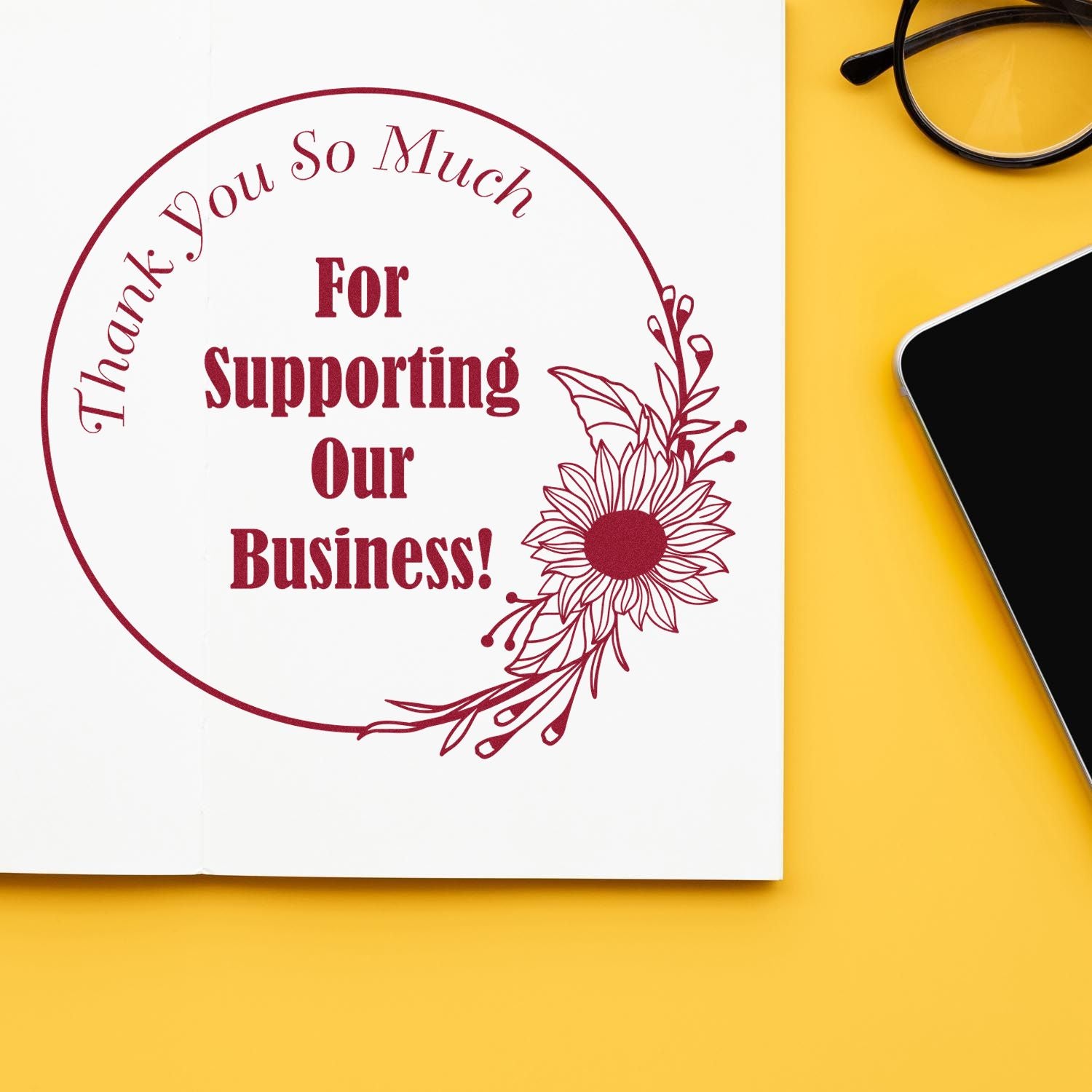 Maroon thank-you business stamp seal with floral design on white paper against a yellow background.