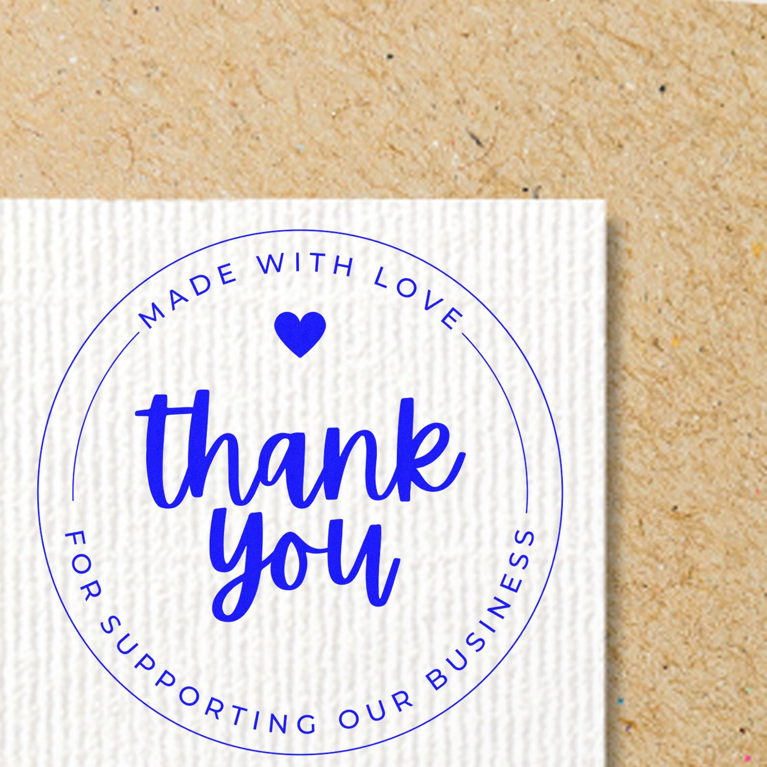 Blue circular thank-you stamp seal on white textured card, reading Made with Love and Thank You against a tan background.