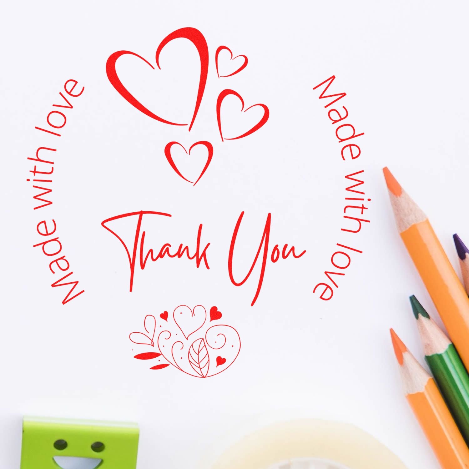 Red heart-shaped stamp and seal designs reading Thank You and Made with love on white paper with colored pencils.