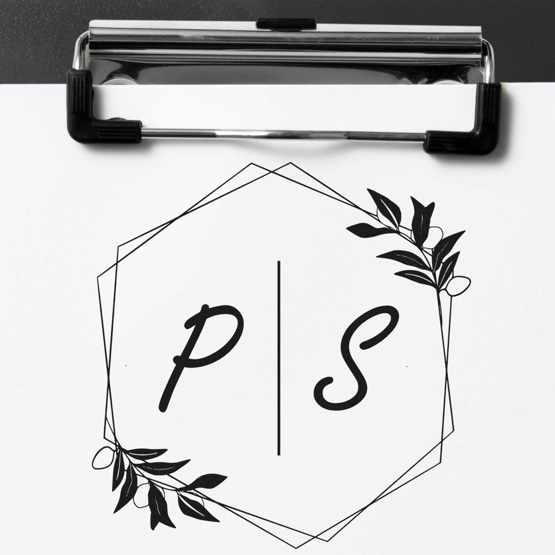 Black custom stamp and seal design with geometric hexagon, leafy accents, and PS initials on white clipboard paper.