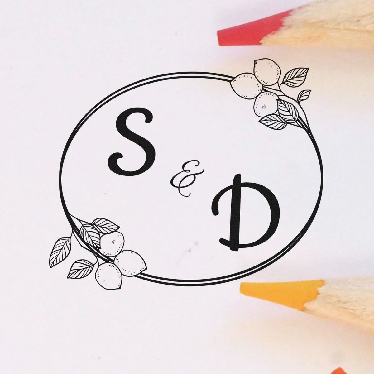 Black S & D monogram stamp seal with oval floral border on white, accented by red and yellow pencil tips.