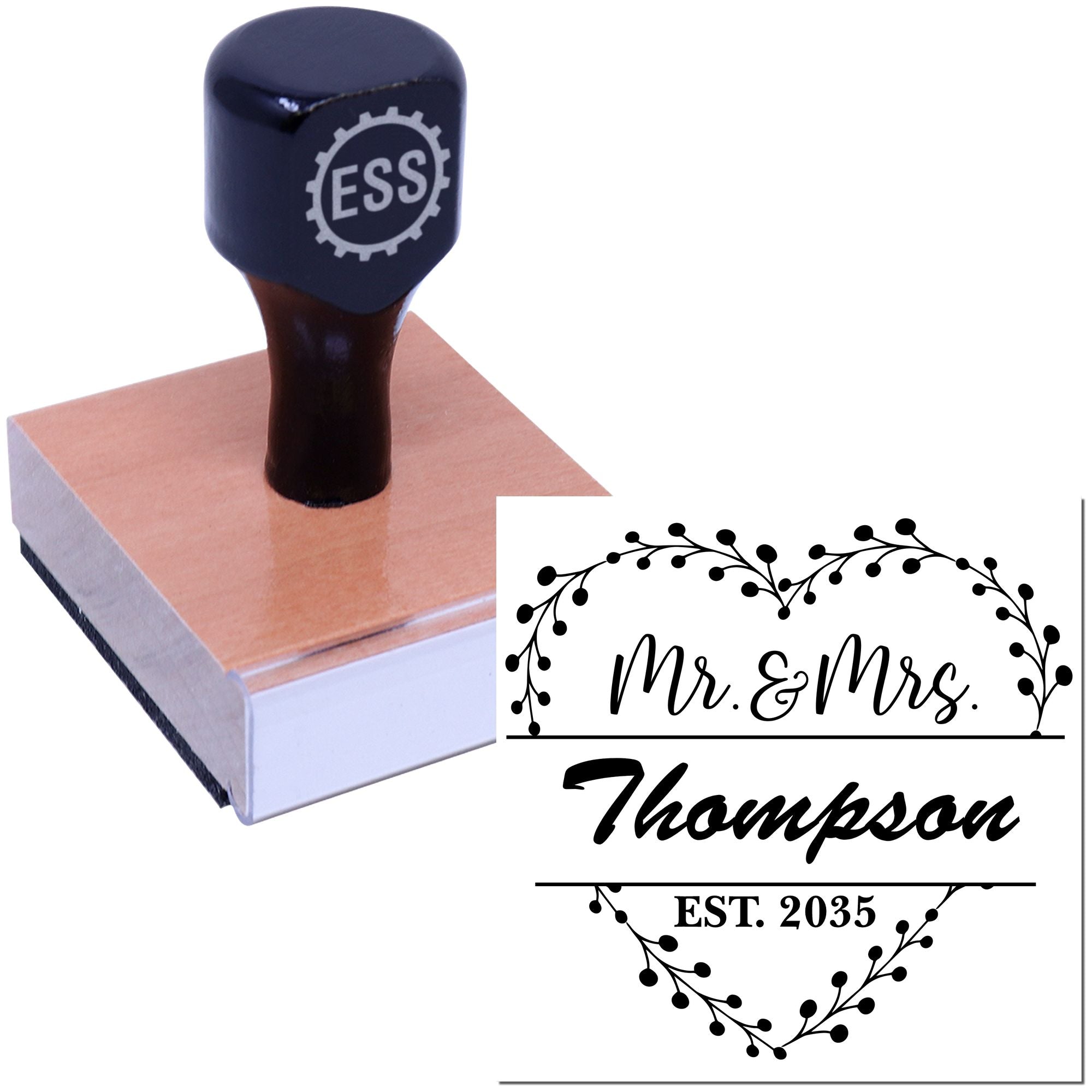 Black custom stamp on a pink wooden block, showing a floral Mr. & Mrs. Thompson EST. 2035 wedding seal.
