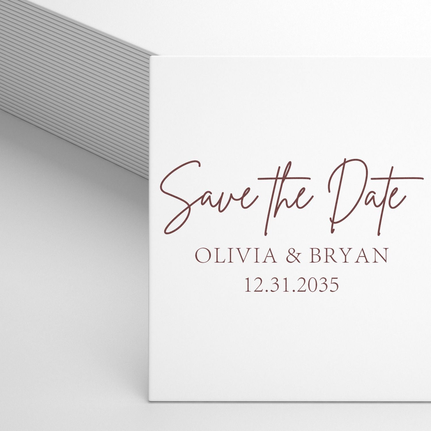 White wedding save-the-date stamp and seal with burgundy script, Olivia & Bryan, 12.31.2035, on a gray ribbed envelope.