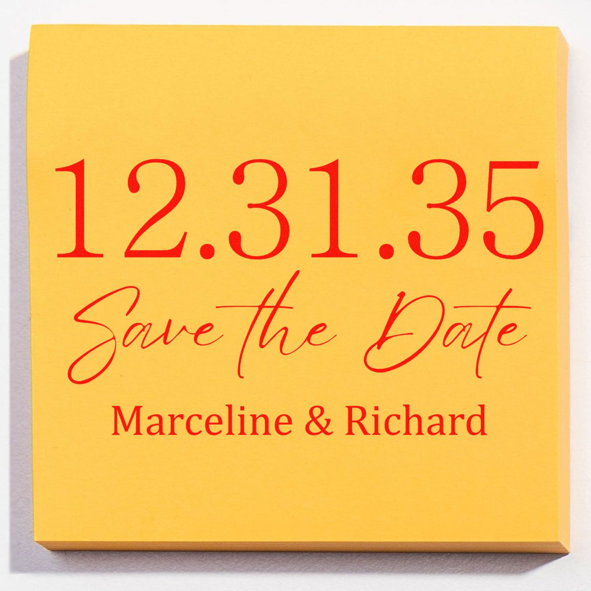 Yellow sticky note with a red custom stamp-style Save the Date design: 12.31.35 Marceline & Richard.