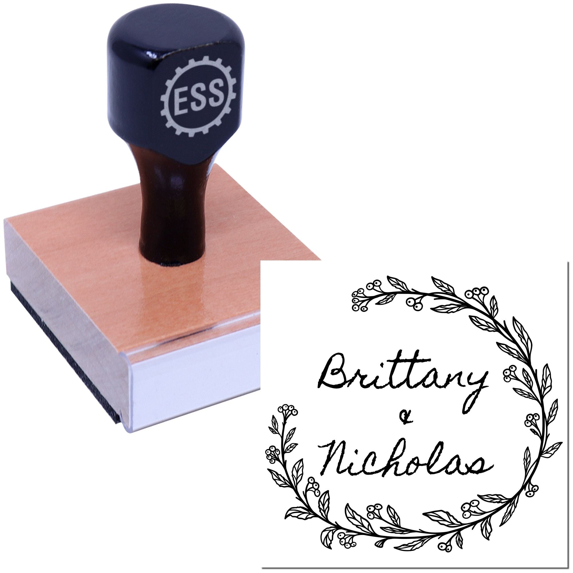 Dark navy custom rubber stamp on wooden block with black floral wreath seal reading Brittany Nicolas on white background