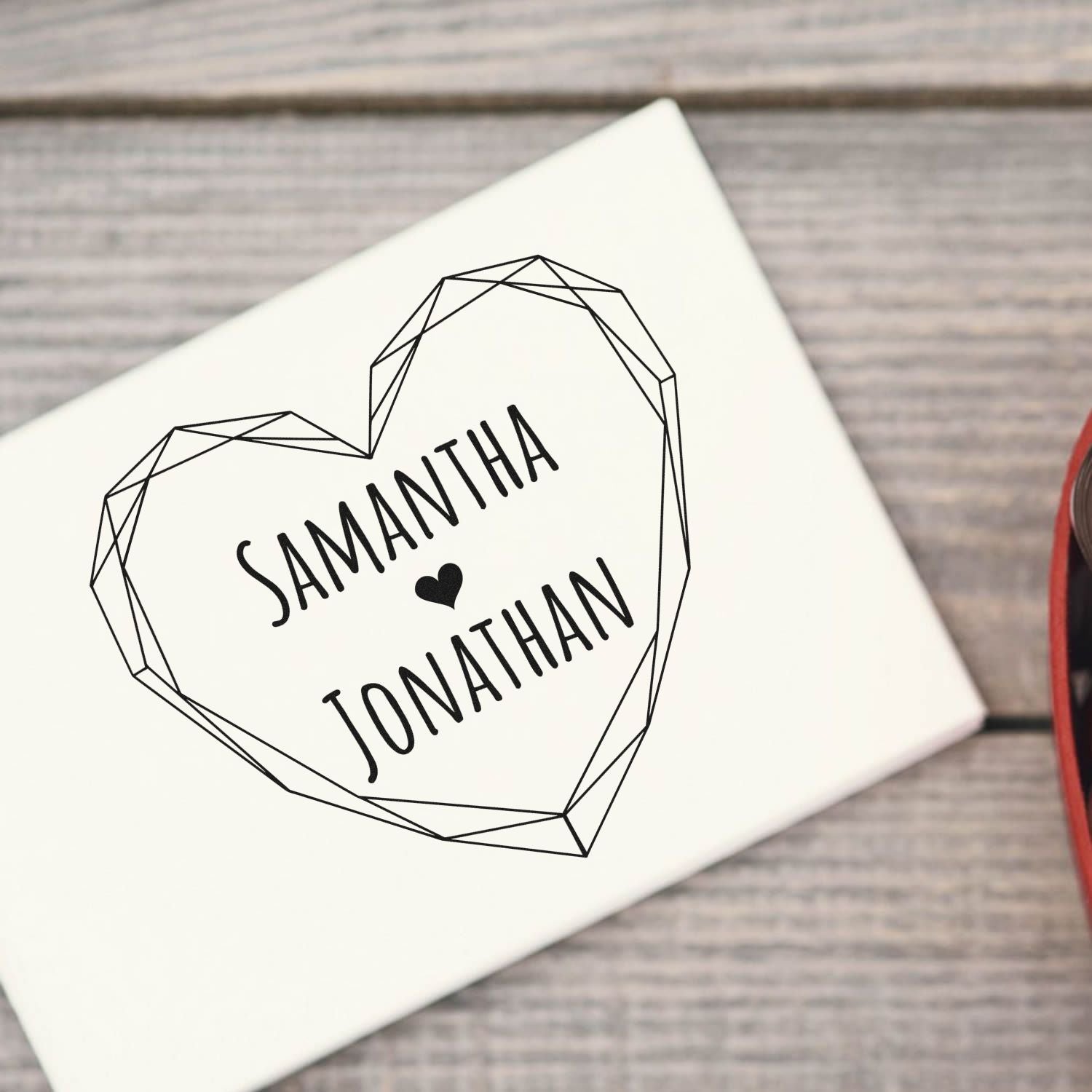 Custom black wedding stamp seal with geometric heart and names Samantha and Jonathan on white card.