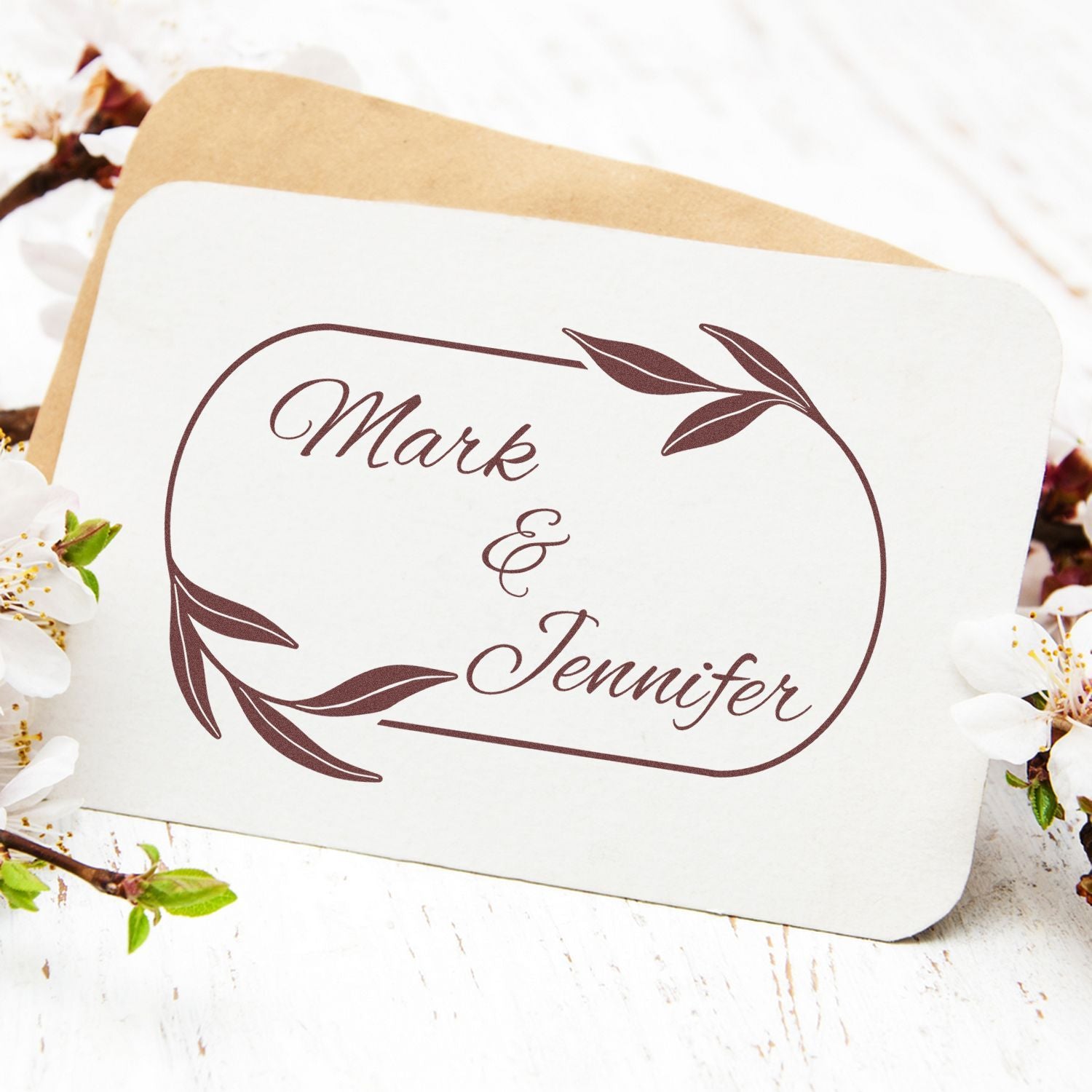 Custom brown wedding stamp and seal with Mark & Jennifer on white card, leaf design, tan envelope and floral accents