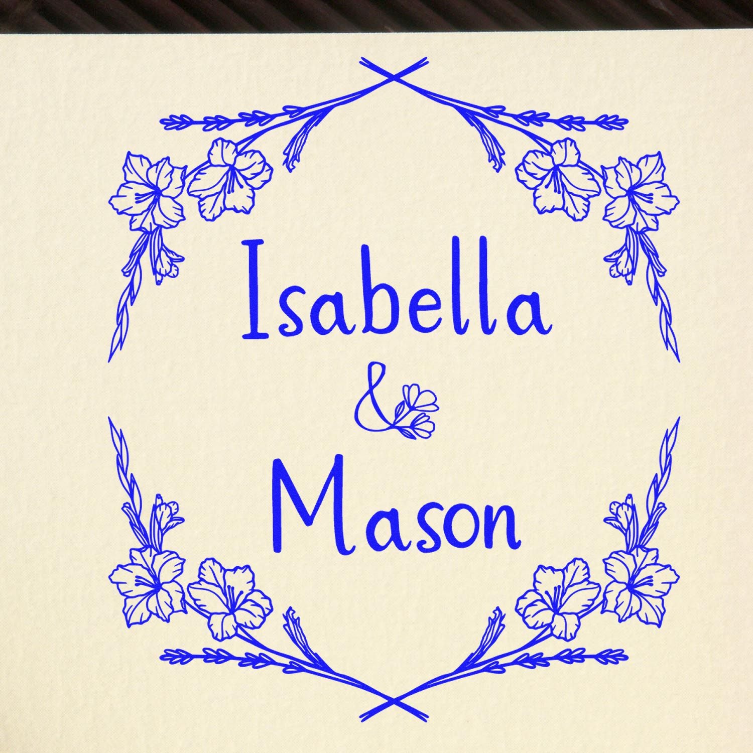 Custom blue floral stamp and seal with Isabella & Mason on cream background, featuring delicate flower and leaf border.