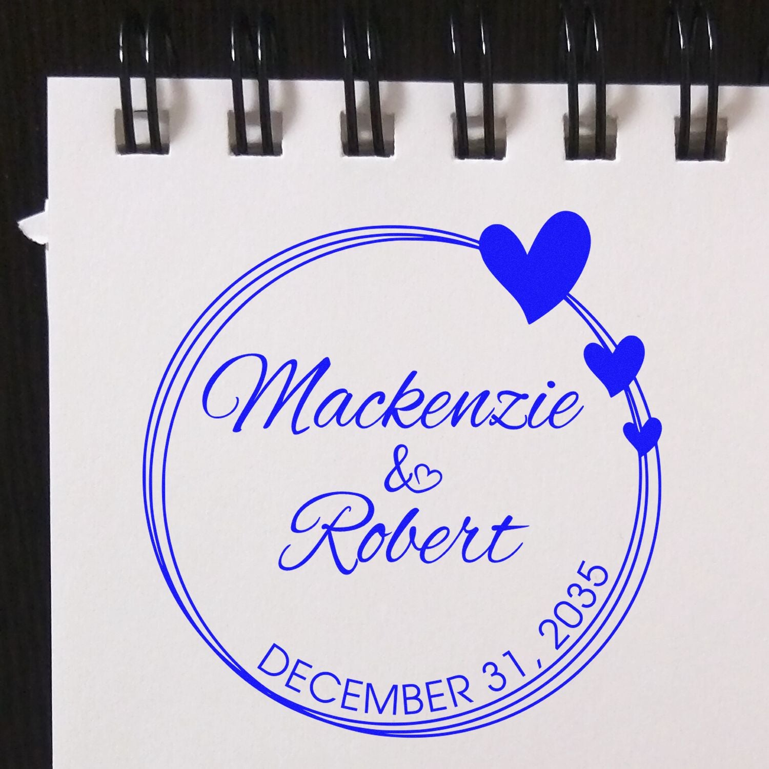 Blue custom wedding stamp seal with hearts, reading Mackenzie & Robert and December 31, 2035.