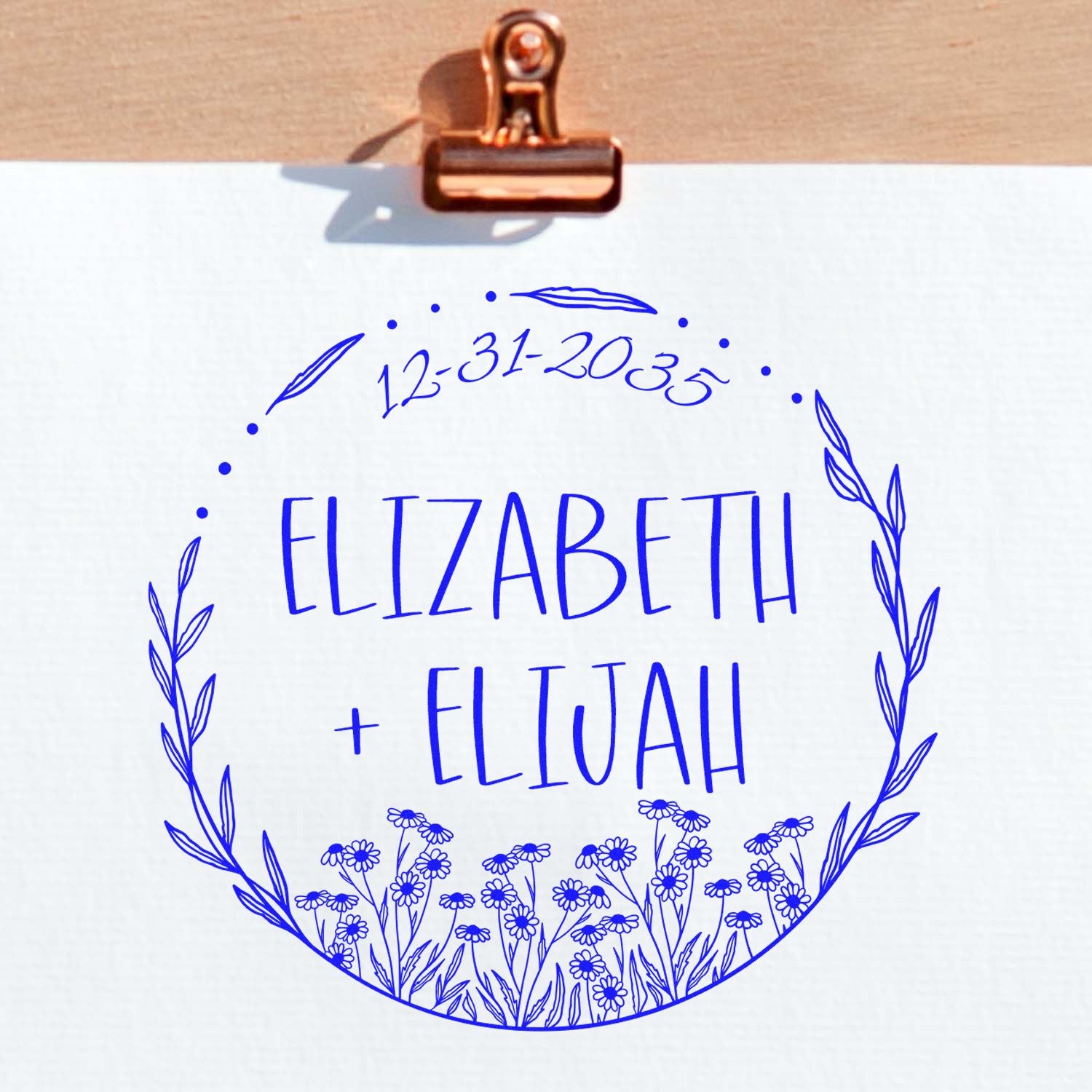 Blue floral custom wedding stamp and seal for Elizabeth + Elijah with date 12-31-2035 on white paper