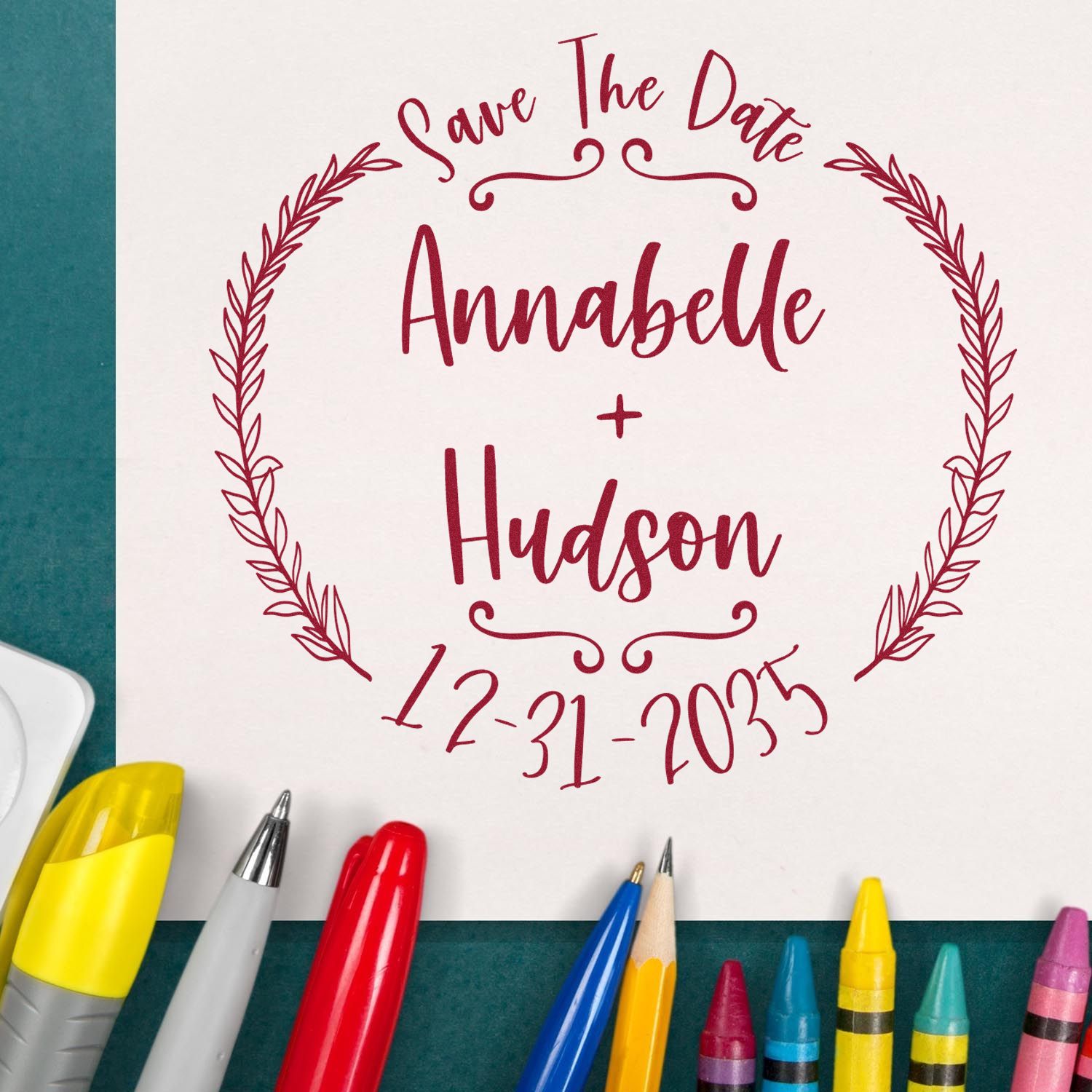 Custom burgundy save the date stamp with laurel wreath, Annabelle + Hudson, and 12-31-2035 on white paper