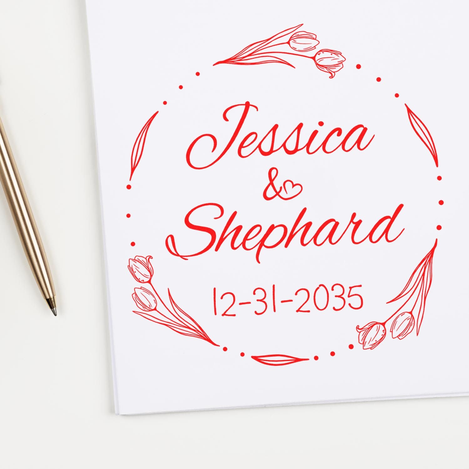 Red floral wedding stamp seal with Jessica & Shephard and 12-31-2035 on white paper, beside a gold pen.
