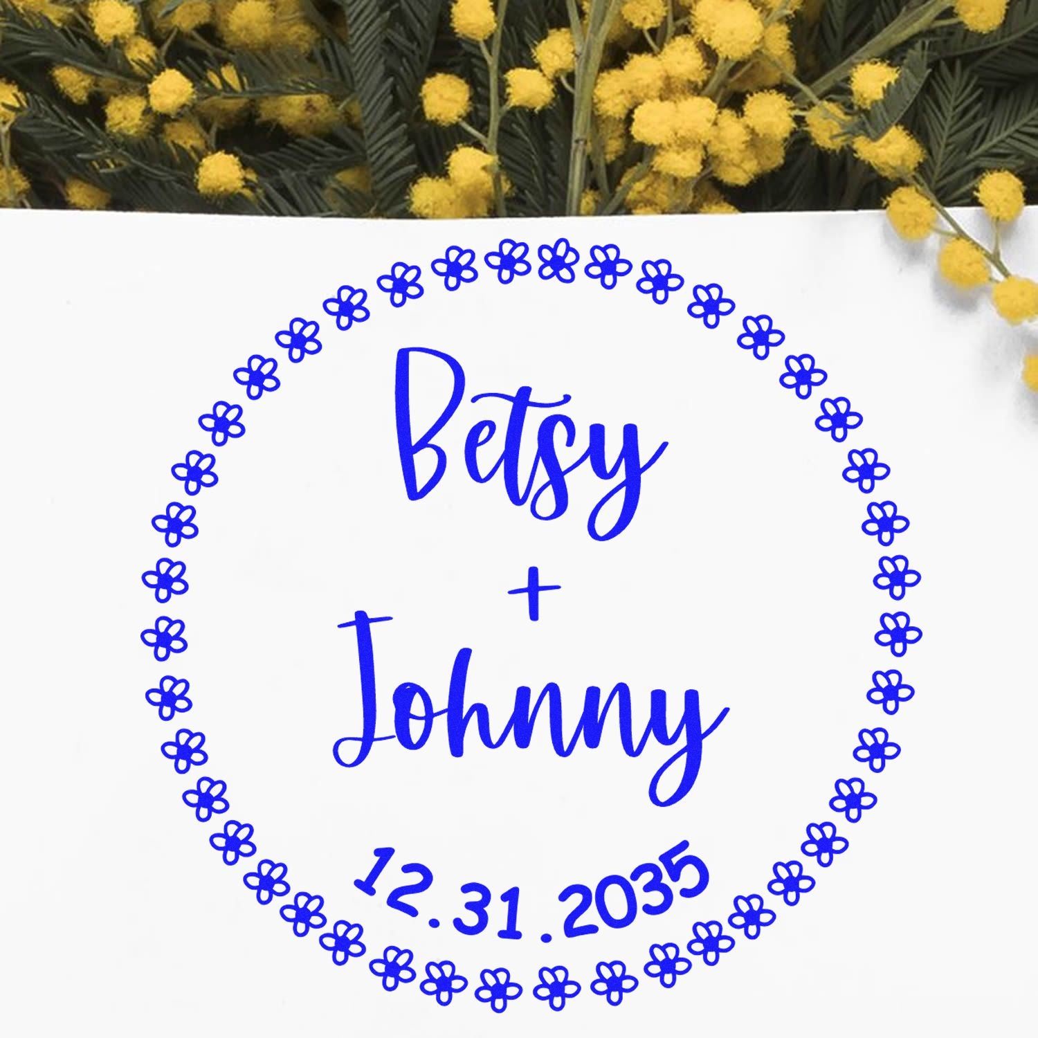 Blue floral wedding seal stamp reading Betsy + Johnny, 12.31.2035, on white background with yellow blooms.